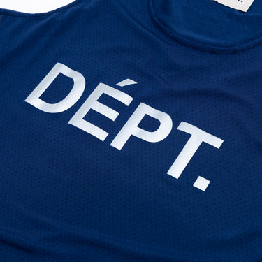 Close-up of the white “DÉPT.” logotype on the front of a navy blue athletic tank top, highlighting the bold lettering and the small perforations in the breathable fabric.