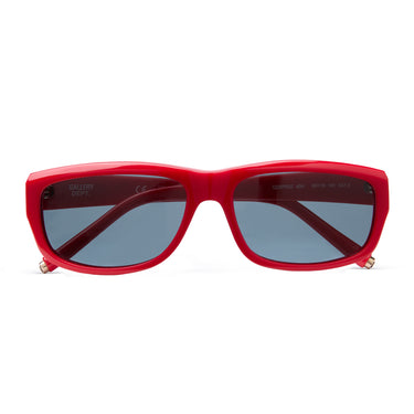 Red rectangular sunglasses with dark gray lenses, folded on a white background with gold 'G-Ball' studs on the ear tip, shown on a plain white background.