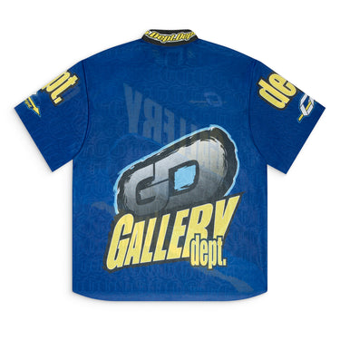 Back view of a blue short sleeve mock neck jersey featuring all-over sublimated "GALLERY DEPT." graphics, woven "dept.dept." collar trim, and a raw hem.