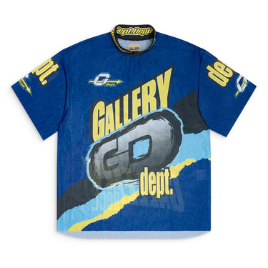Front view of a blue short sleeve mock neck jersey with all-over sublimated "GALLERY DEPT." graphics, woven "dept.dept." collar trim, and a raw hem.