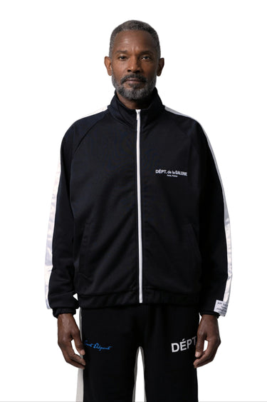 A man modeling a black track jacket with white side stripes and white logo details, on a white background.