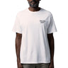 A man wearing a white short-sleeve t-shirt with 'GALLERY DEPT.' printed in black on the left chest, paired with gray trousers and black sunglasses, against a white background.
