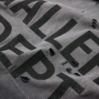 Close-up of the black glitter "GALLERY DEPT." logo on the back, showcasing the faded wash and distressed fabric.