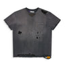 Front view of a faded charcoal relaxed fit short sleeve tee with heavy distressing throughout, a chest pocket, raw hem, and scattered holes across the front.