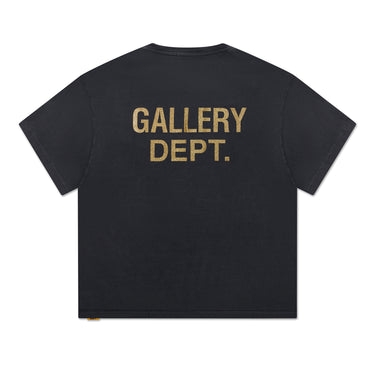 Back of faded black short sleeve T-shirt featuring a gold glitter GALLERY DEPT. logo printed across the upper back.