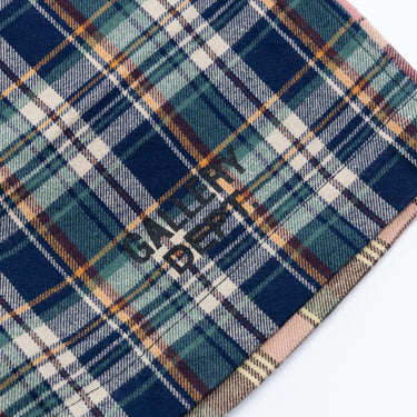 Close-up of the blue plaid athletic shorts against a white background, highlighting the navy, light blue, cream, and orange plaid lines and the dark “GALLERY DEPT.” logotype printed near the hem.